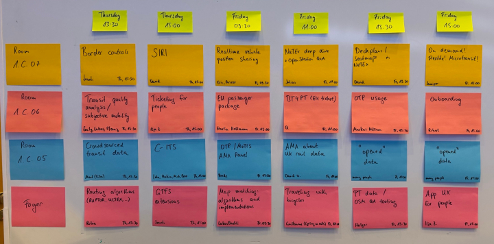 Whiteboard with a grid of colorful post-its with the unconference session schedule.